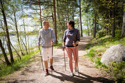 Frau und Mann beim Nordic Walking im Wald