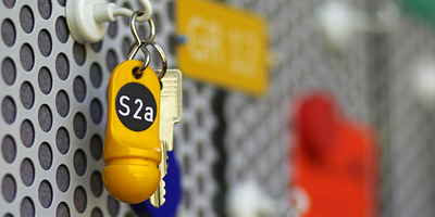 Typischer Hotelschlüssel mit dickem gelbem Anhänger und der Zimmernummer 